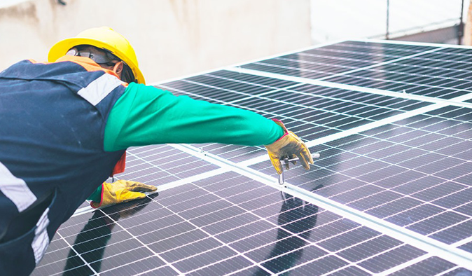Solar technician installs solar panel outdoors in the installation services.