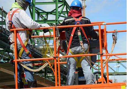 Workers elevated on platform of a boom lift attached to lift platform with fall protection gear. 