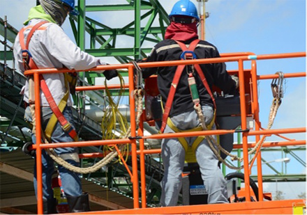 Workers elevated on platform of a boom lift attached to lift platform with fall protection gear.