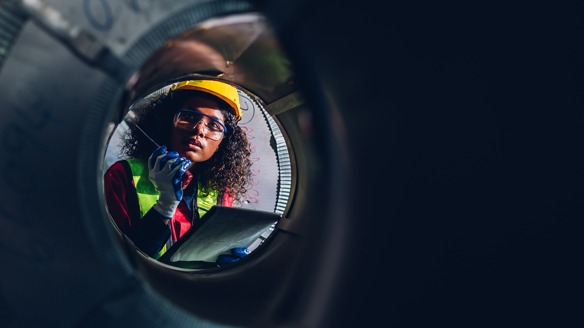 Looking ahead to safety dates for 2025 - image of female construction worker through pipe